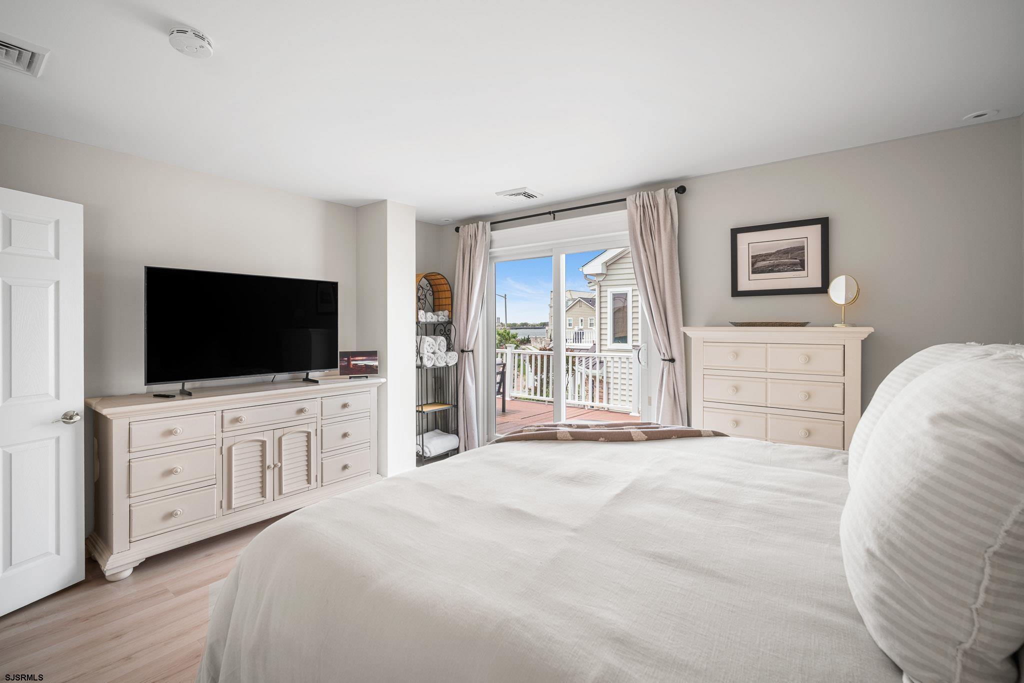 5217 Seaspray Road Brigantine, NJ 08203 - Photo 28 of 35 a bedroom with a large bed and a flat screen tv