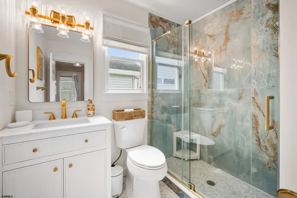 a bathroom with a sink toilet vanity and shower