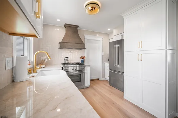 a kitchen with stainless steel appliances a stove a refrigerator and a wooden floor