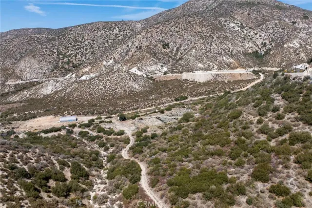 a view of a dry yard with wooden fence