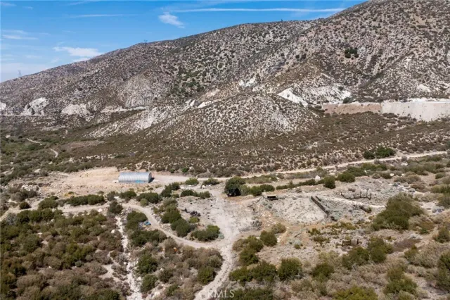 a view of a dry yard with wooden fence