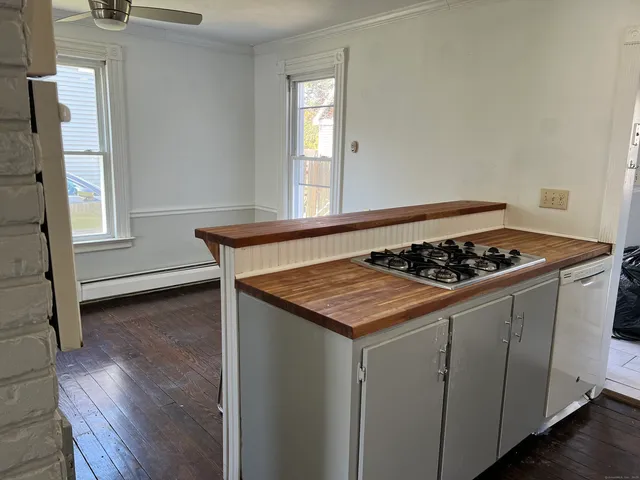 a kitchen that has a stove and a wooden floor