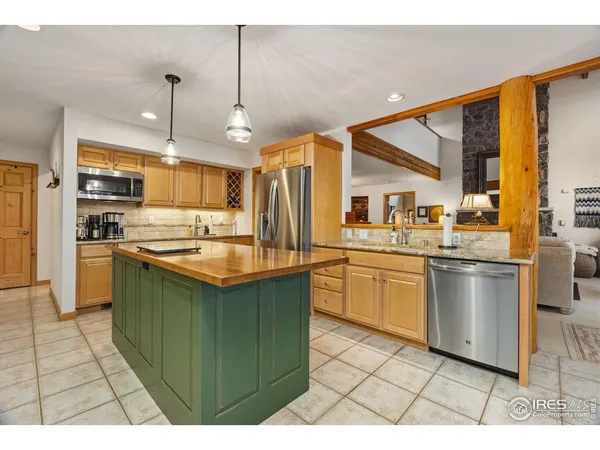 a kitchen with granite countertop a refrigerator and a sink