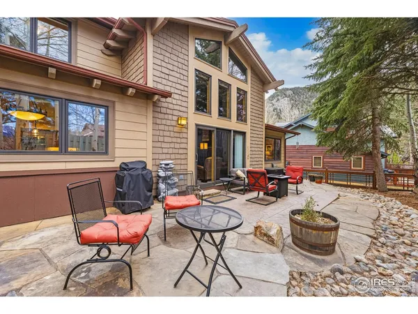 a view of a patio with table and chairs with wooden fence