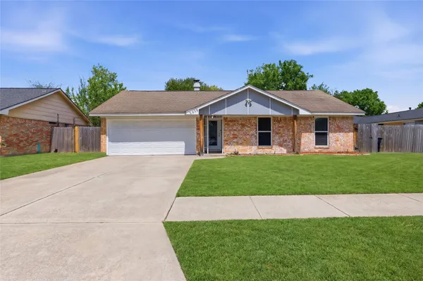 a front view of a house with a garden and yard