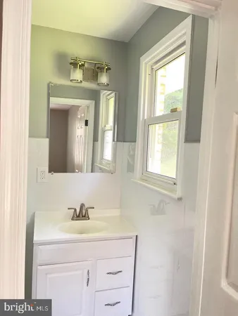 a bathroom with a sink vanity and a mirror
