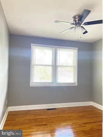 an empty room with window and ceiling fan