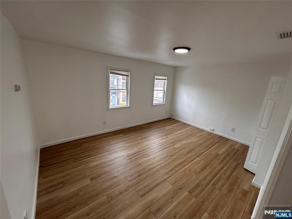 224 Fort Lee Road Bogota, NJ 07603 - Photo 2 of 12 an empty room with wooden floor and windows