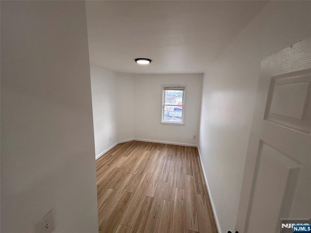 224 Fort Lee Road Bogota, NJ 07603 - Photo 9 of 12 a view of an empty room with wooden floor and a window