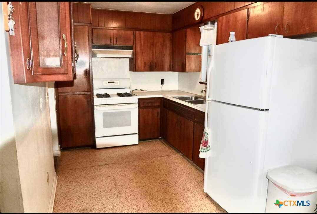 141 Jackson Street Elgin, TX 78621 - Photo 12 of 28 a kitchen with a white stove top oven and refrigerator