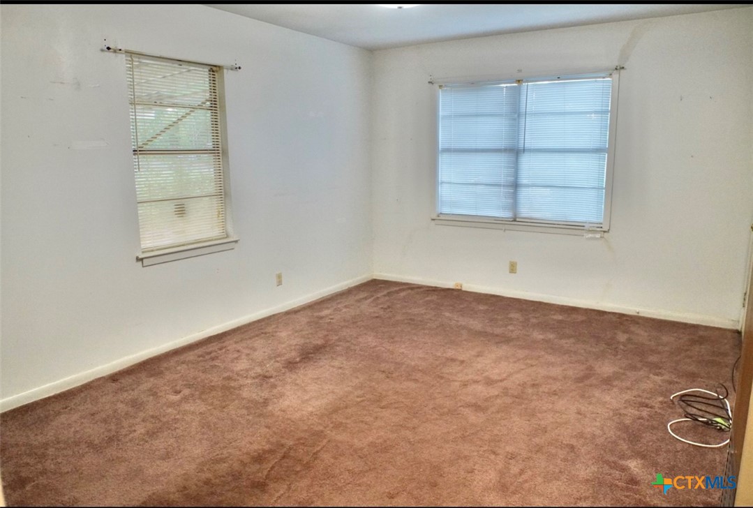 141 Jackson Street Elgin, TX 78621 - Photo 16 of 28 an empty room with cabinet and windows