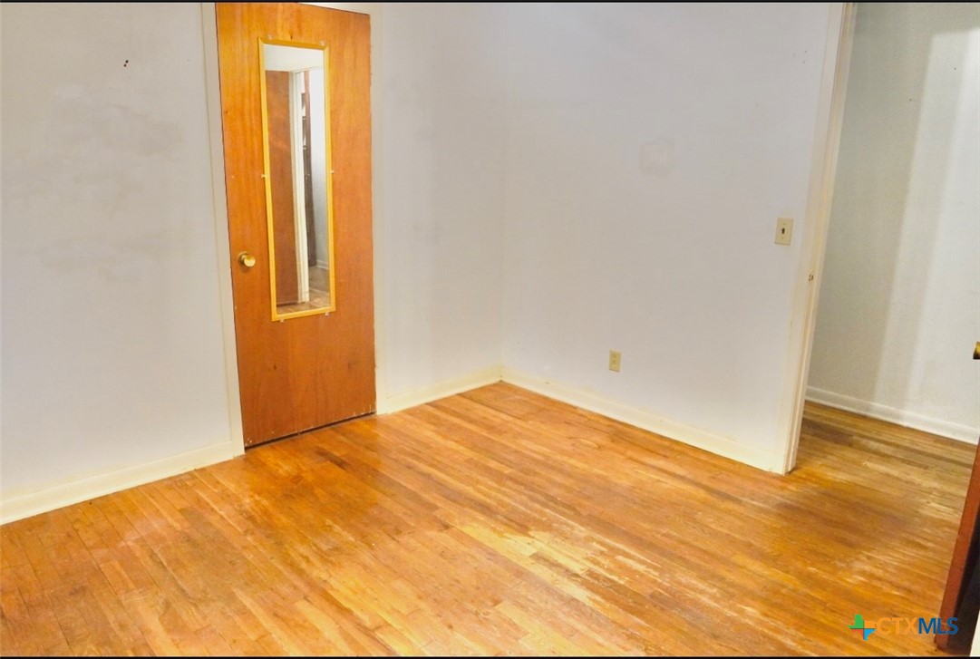 141 Jackson Street Elgin, TX 78621 - Photo 19 of 28 a view of empty room with wooden floor