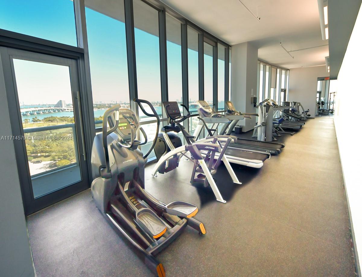 888 Biscayne Boulevard, Unit 2511 Miami, FL 33132 - Photo 17 of 26 a room with gym equipment and a large window