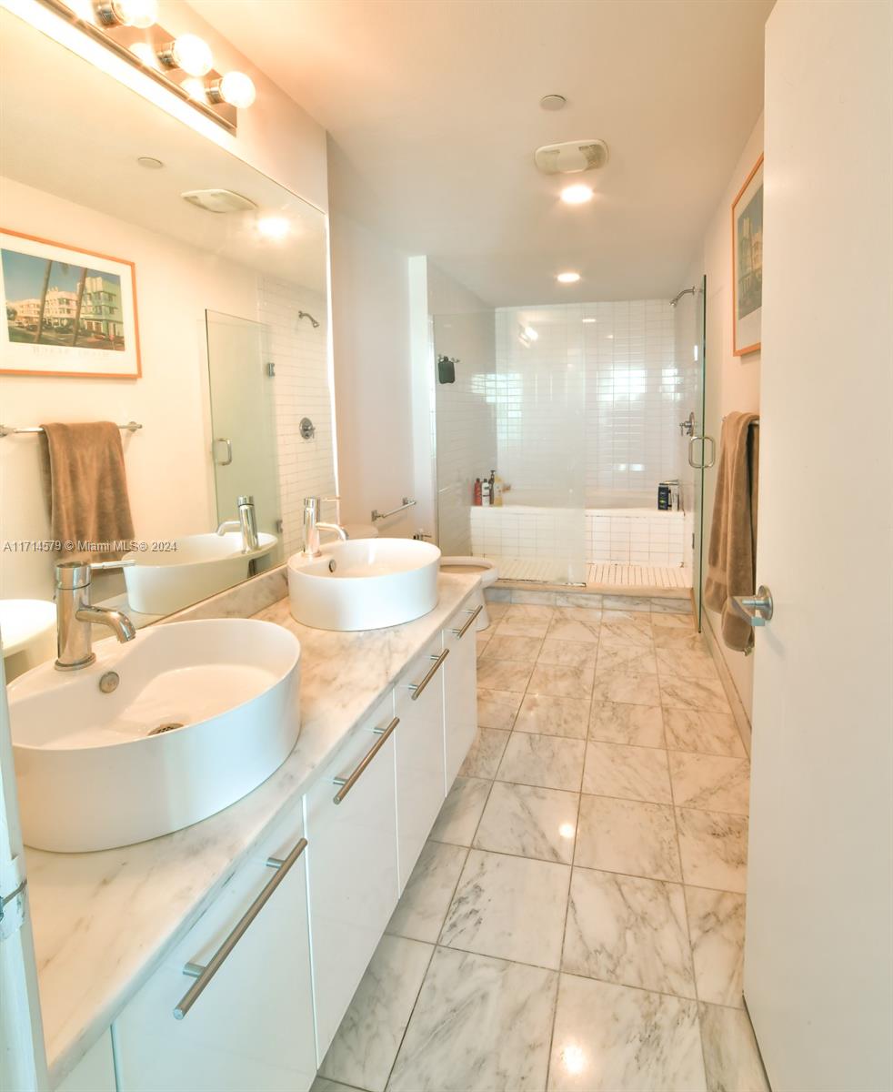 888 Biscayne Boulevard, Unit 2511 Miami, FL 33132 - Photo 8 of 26 a bathroom with a double vanity sink mirror and shower