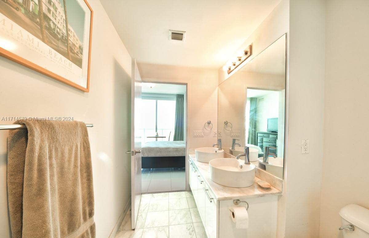 888 Biscayne Boulevard, Unit 2511 Miami, FL 33132 - Photo 9 of 26 a bathroom with a sink a mirror and a shower