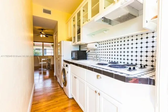 a kitchen with granite countertop a sink and a wooden floor