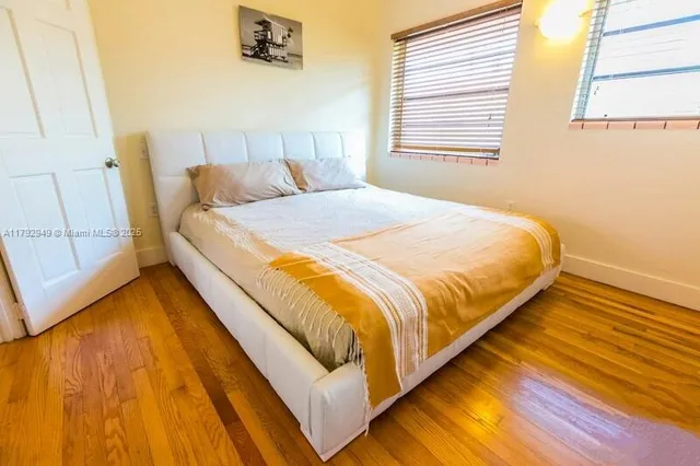 a large bed sitting in a bedroom next to a window
