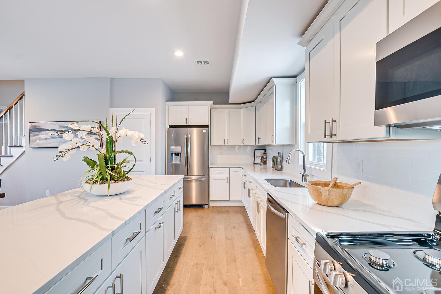 31 Sturgis Road Edison, NJ 08817 - Photo 13 of 35 a kitchen with stainless steel appliances granite countertop a sink a stove and a wooden floors