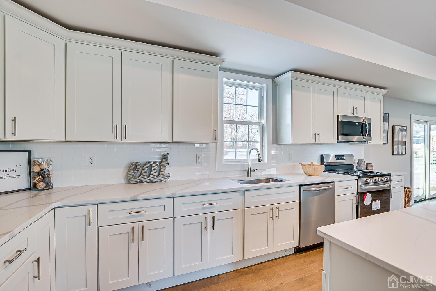 31 Sturgis Road Edison, NJ 08817 - Photo 15 of 35 a kitchen with cabinets stainless steel appliances a sink and a window
