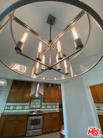 a large kitchen with stainless steel appliances a large counter top space a sink and a stove