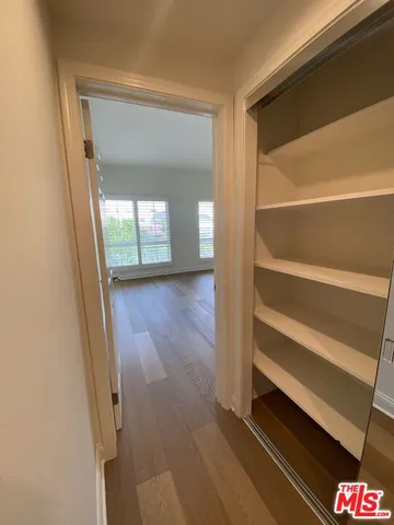 a view of empty room with window and wooden floor