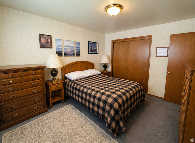 1611 South 75 East Bountiful, UT 84010 - Photo 14 of 23 Carpeted room featuring a ceiling-mounted light fixture, wallpapered walls, and wood-finish sliding closet doors