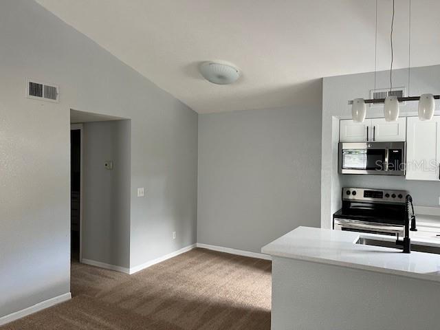 5128 Conroy Road, Unit 22 Orlando, FL 32811 - Photo 6 of 9 a kitchen with a refrigerator and a stove top oven