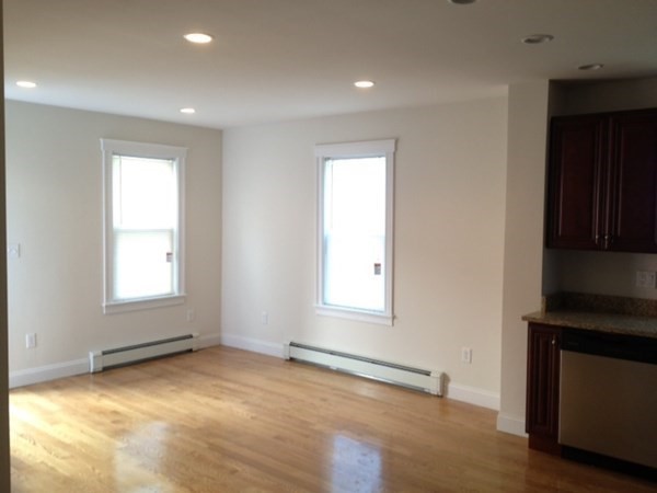 200 Brooks Street, Unit 1 Boston, MA 02128 - Photo 3 of 10 an empty room with wooden floor and windows