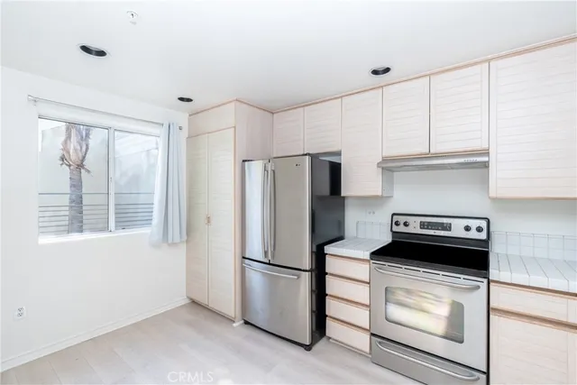a kitchen with a refrigerator stove and white cabinets