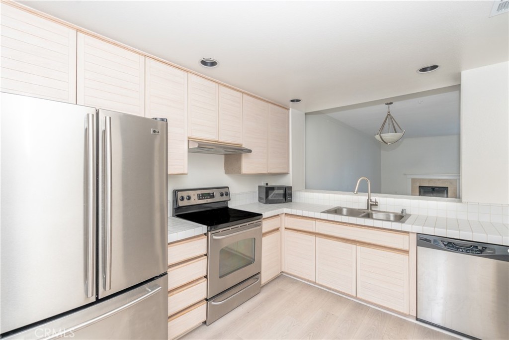 2253 Martin, Unit 416 Irvine, CA 92612 - Photo 3 of 23 a kitchen with white cabinets and white appliances