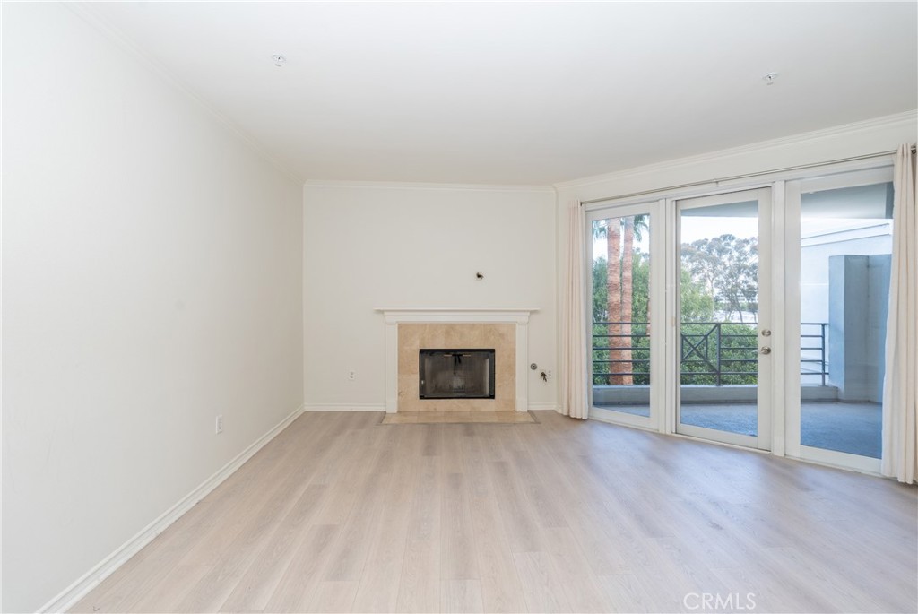 2253 Martin, Unit 416 Irvine, CA 92612 - Photo 9 of 23 an empty room with wooden floor fireplace and windows