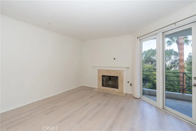 a view of empty room with wooden floor and fireplace