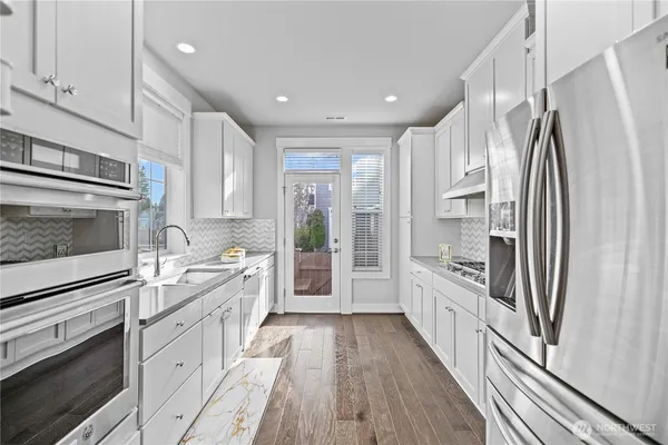 a kitchen with white cabinets and stainless steel appliances