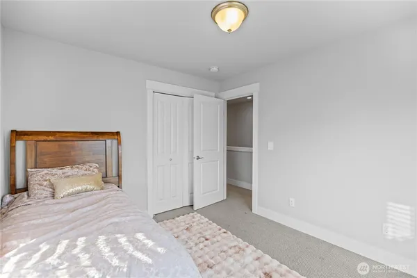 a bedroom with a bed and a lamp on dresser