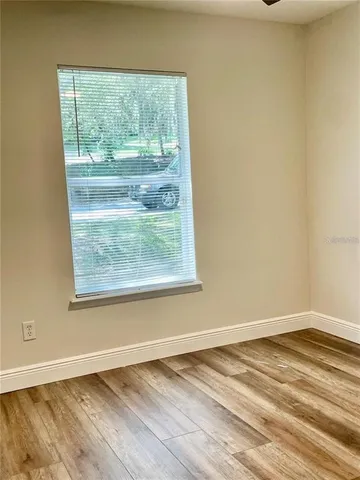 a view of a room with wooden floor and a window