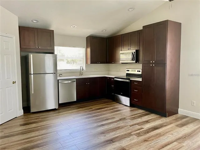 a kitchen with stainless steel appliances granite countertop a refrigerator and a sink