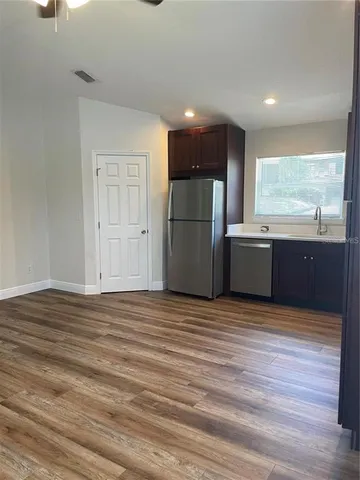 a view of kitchen with refrigerator microwave and wooden floor