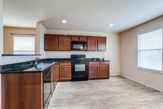 a kitchen with granite countertop a stove and a sink
