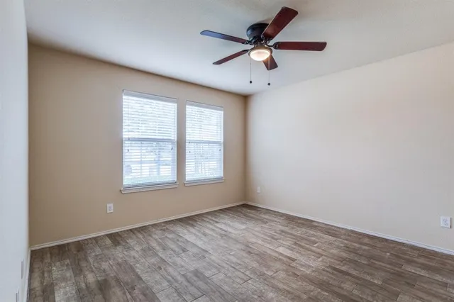 an empty room with a window and a fan
