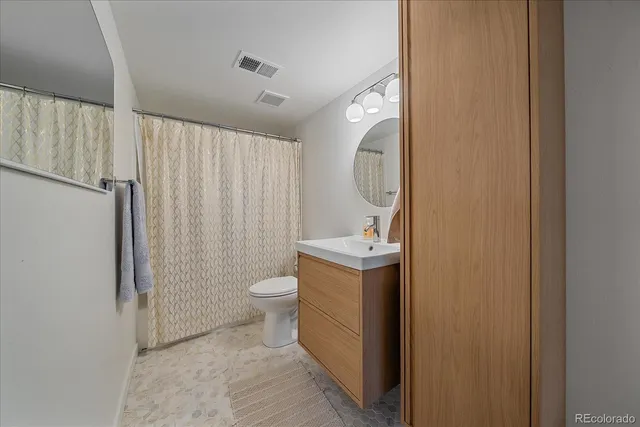 a bathroom with a sink toilet and a mirror
