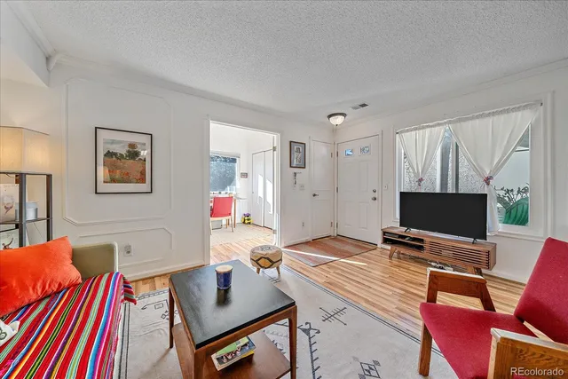 a living room with dining room and wooden floor