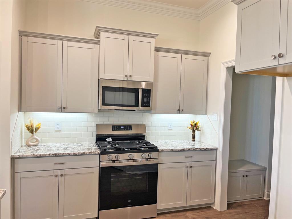 159 Lessie Drive Stonewall, LA 71078 - Photo 11 of 26 a kitchen with granite countertop white cabinets and stainless steel appliances