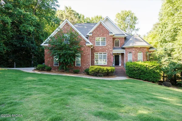 a front view of a house with a yard and trees