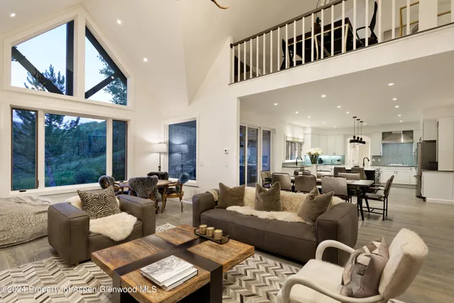 a living room with furniture wooden floor and a large window