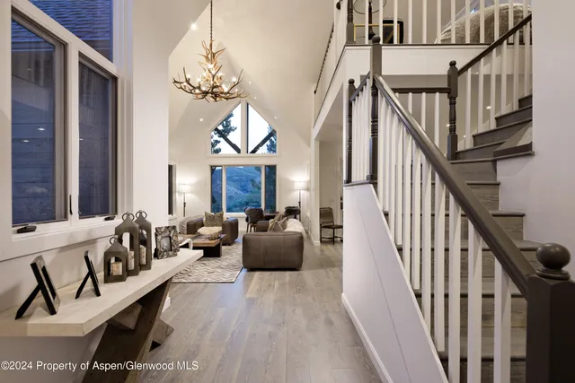 a living room with wooden floor and stairs