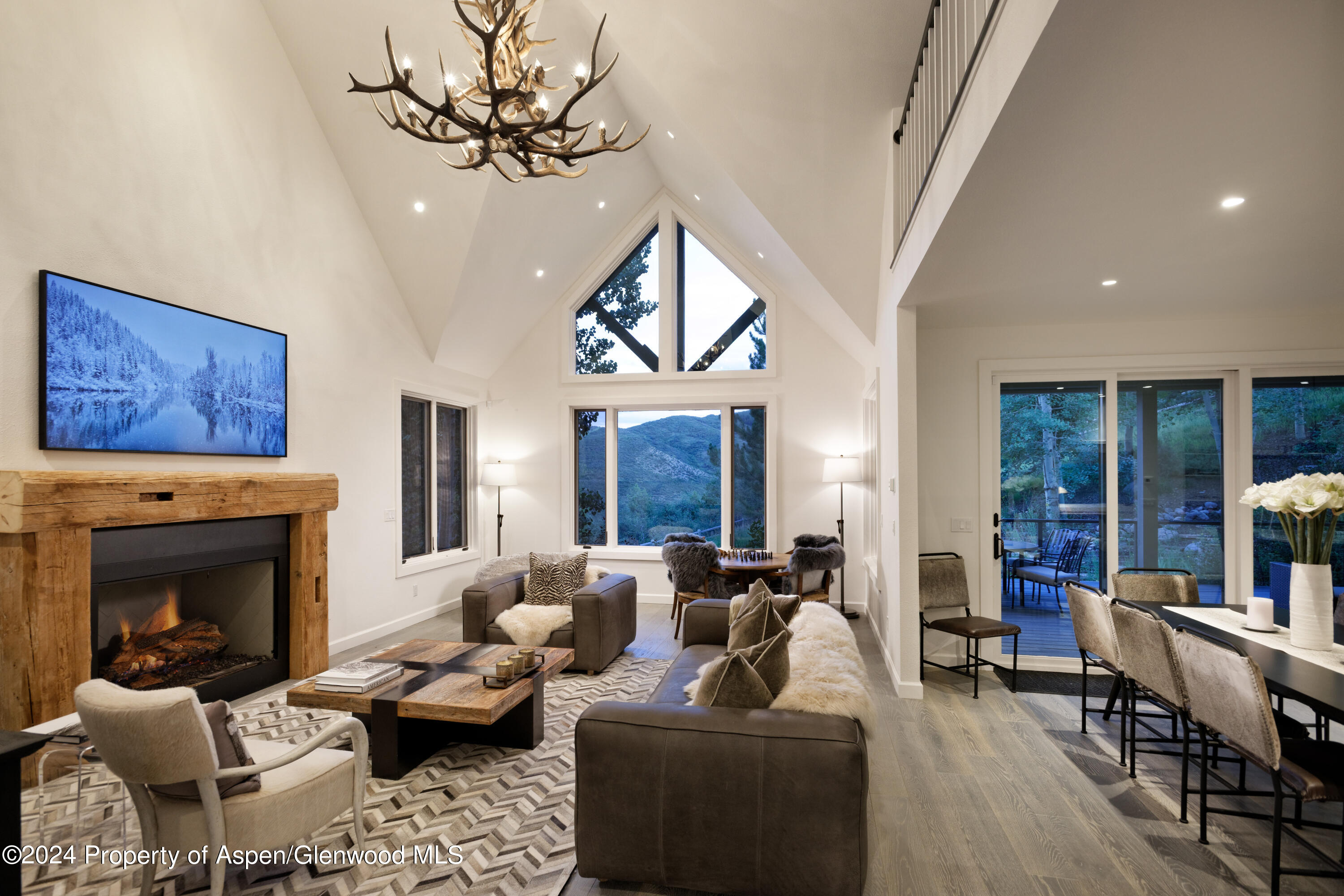 400 Medicine Bow Road Aspen, CO 81611 - Photo 2 of 36 a living room with furniture a fireplace and a chandelier