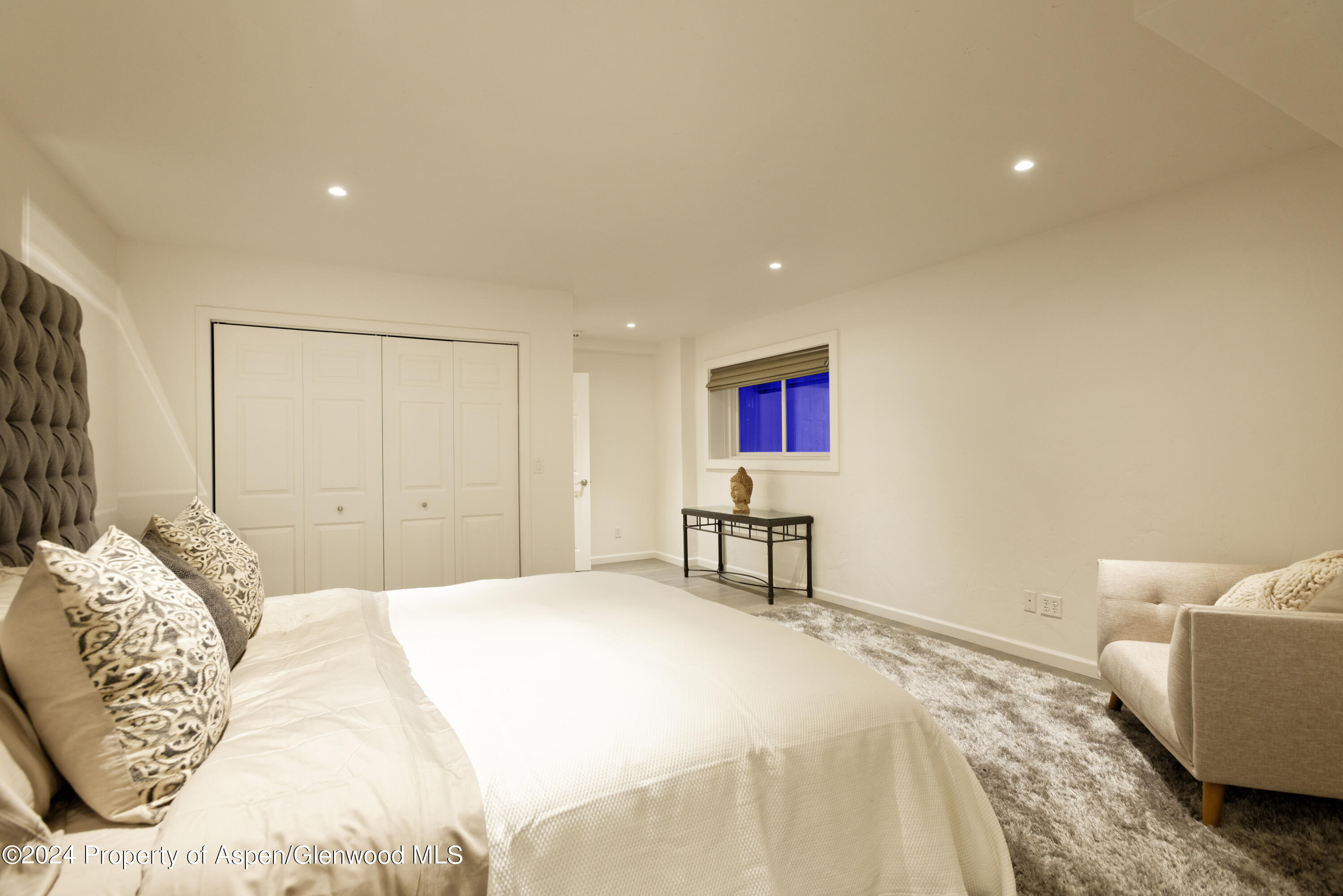 400 Medicine Bow Road Aspen, CO 81611 - Photo 21 of 36 a spacious bedroom with a bed and a table in it