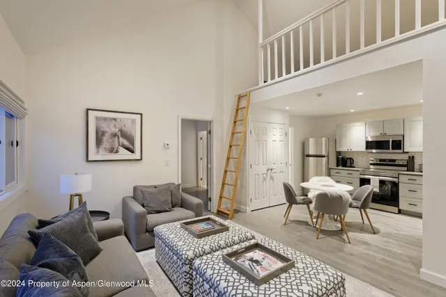a living room with furniture a rug and a kitchen view