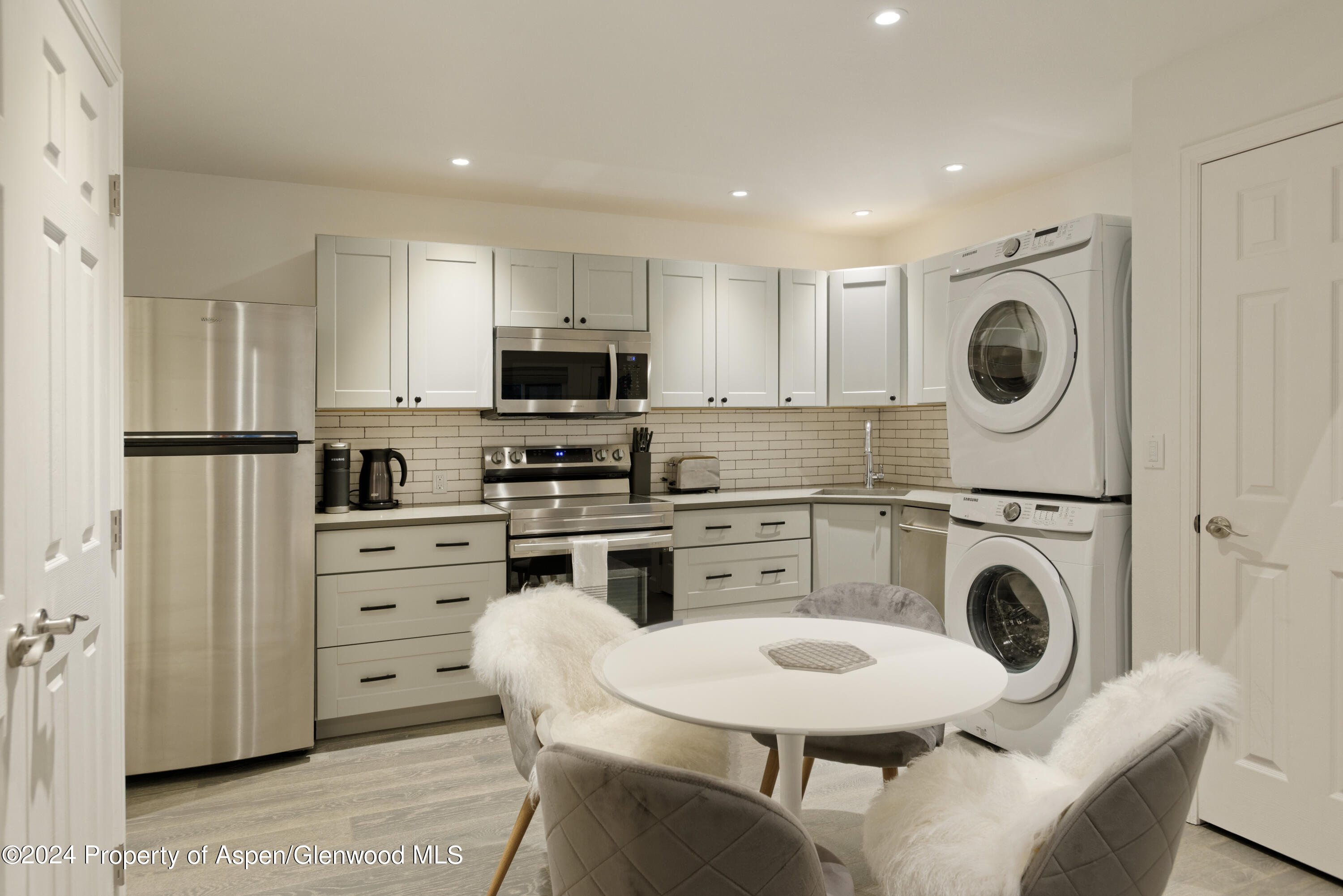 400 Medicine Bow Road Aspen, CO 81611 - Photo 24 of 36 a kitchen with stainless steel appliances granite countertop a stove a sink a refrigerator and white cabinets with wooden floors