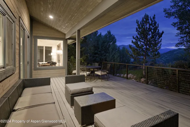 a view of a deck with couches with wooden floor and fence